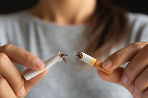 Une personne casse une cigarette en deux avec ses mains, symbolisant l'arrêt du tabac.
