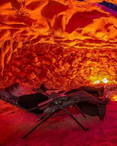 A person is laying in a chair in a cave.