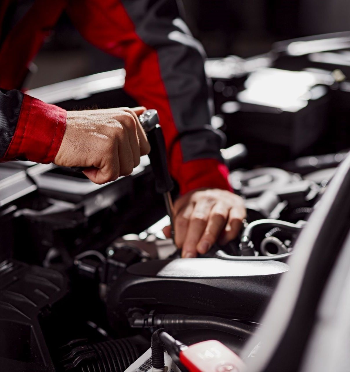 Un mecánico está trabajando en el motor de un coche.