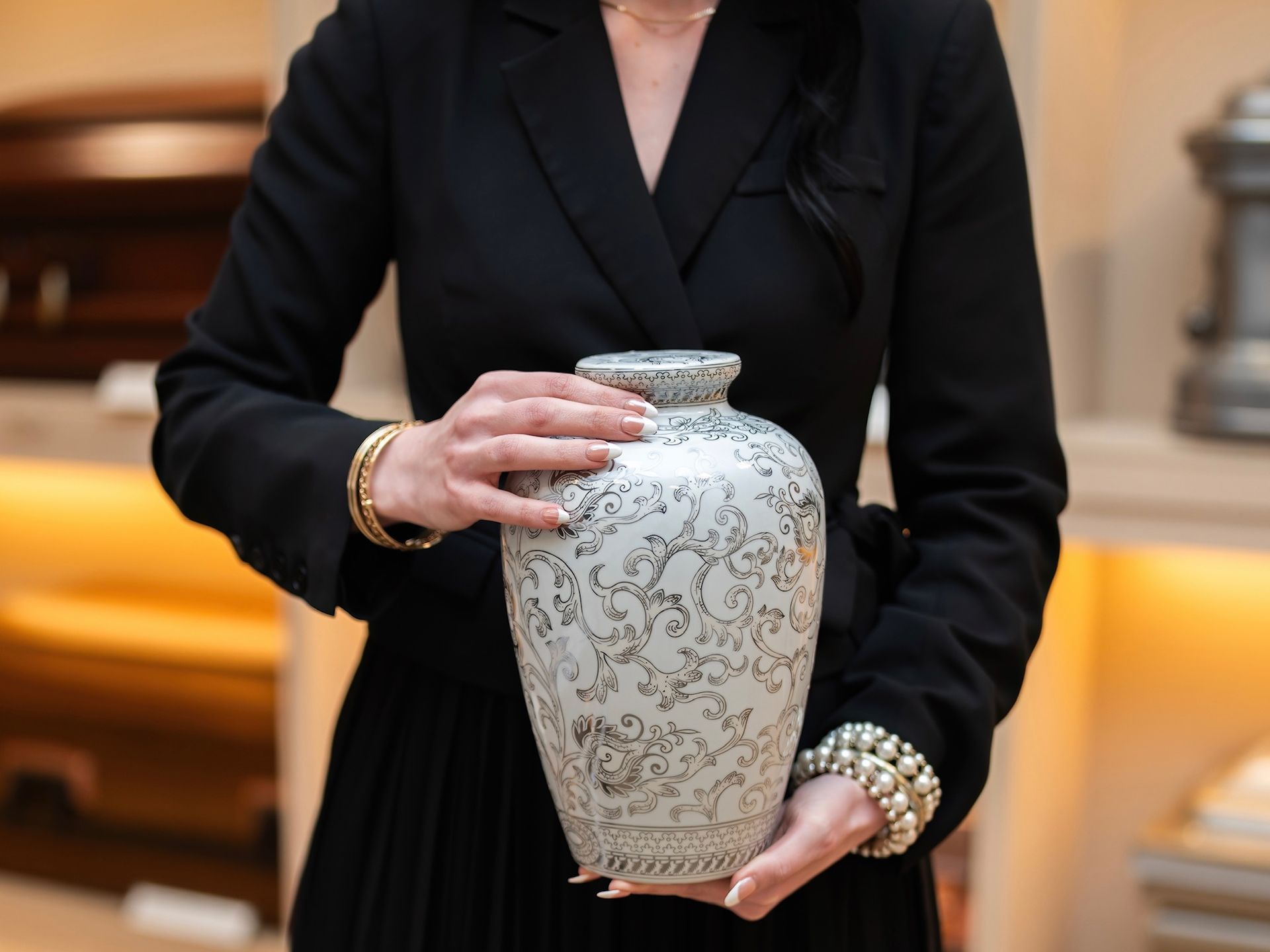 A group of people are standing around a urn at a funeral.