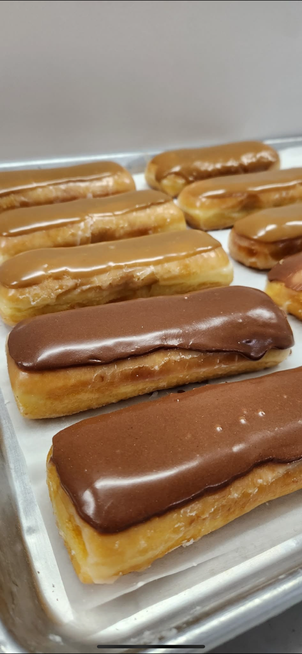 Close-up of a tray of long rectangular pastries, glazed in chocolate and caramel.