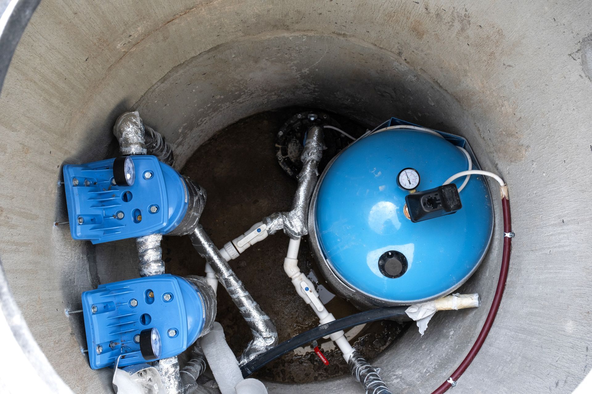 Well pump installation with pressure tank and water system components
