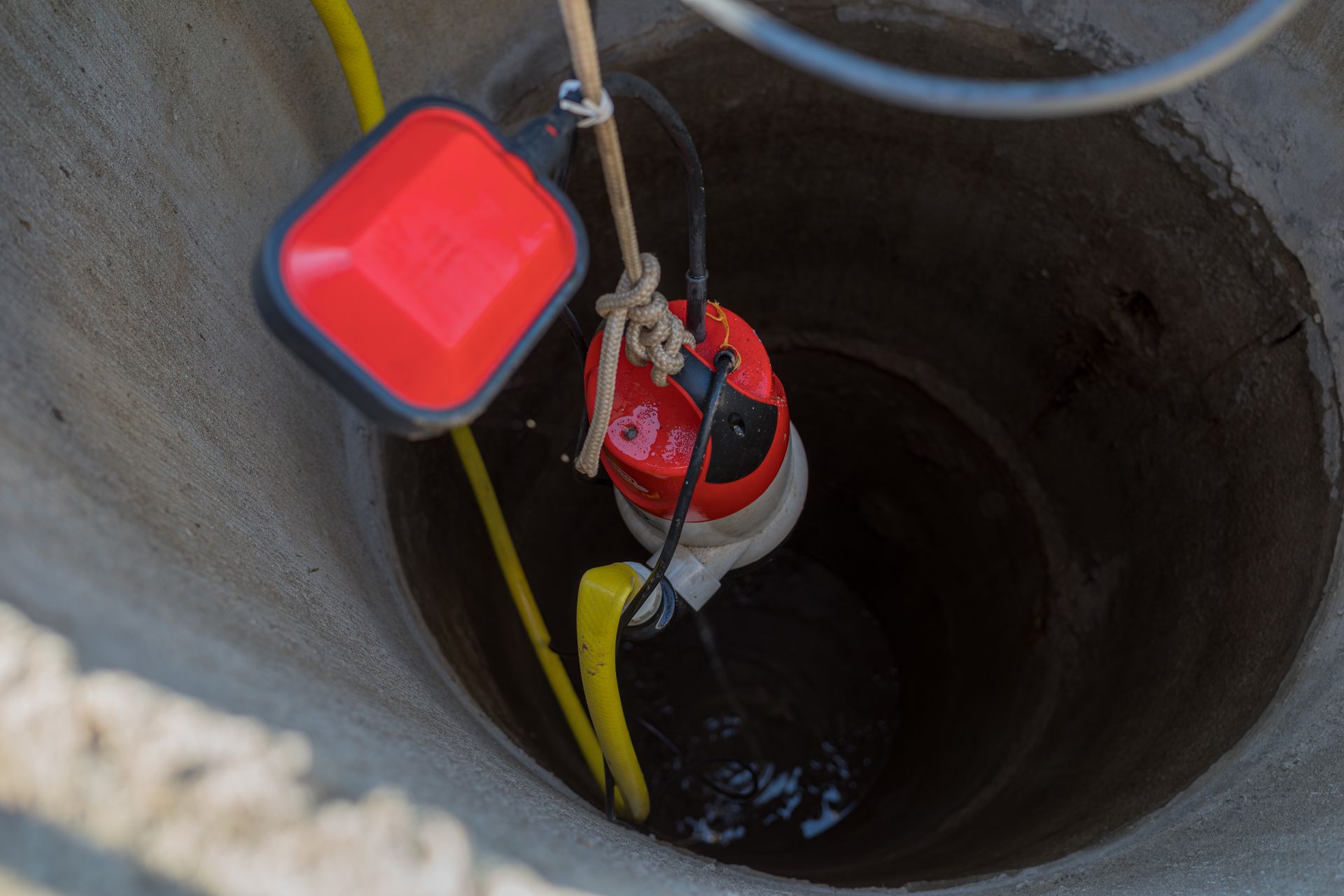 Well pump installation inside a water well with float switch and pump system