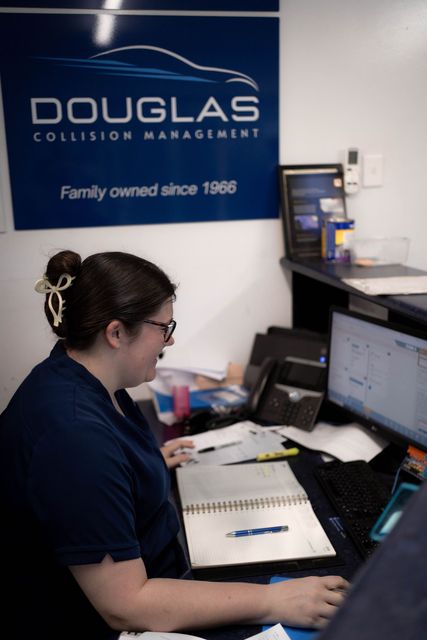 Woman working at a desk in an auto collision repair shop — Douglas Collision Management In Currajong, QLD