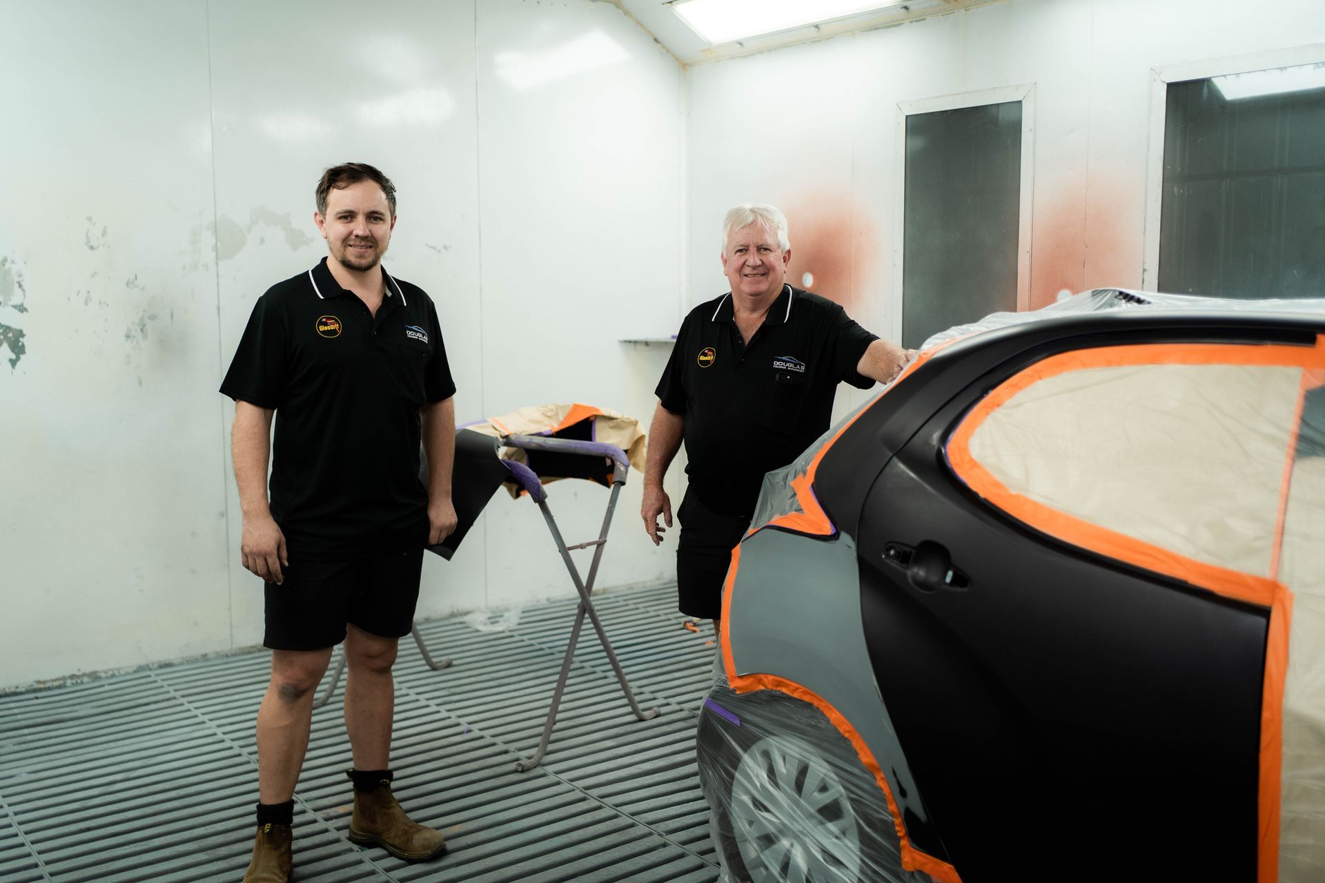 owners Justin and David a painting booth with a car — Douglas Collision Management In Currajong, QLD