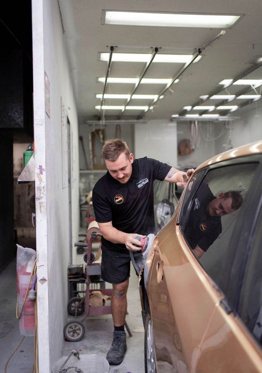 A Man buffing a car before spray painting — Douglas Collision Management In Currajong, QLD