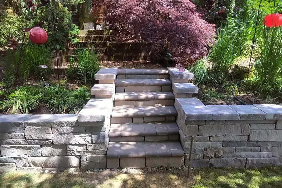 Stone garden steps leading up through landscaped greenery and flowering shrubs