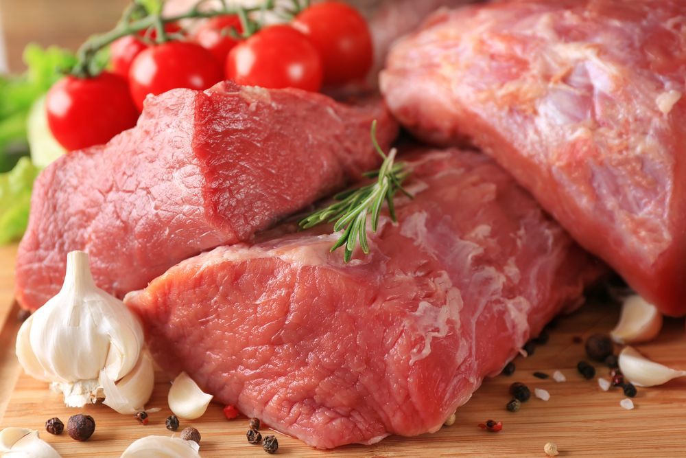 Pieces of different fresh meat on kitchen table — Wholesale Butchery in Condobolin, NSW