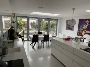 A kitchen with a table and chairs and a painting on the wall.