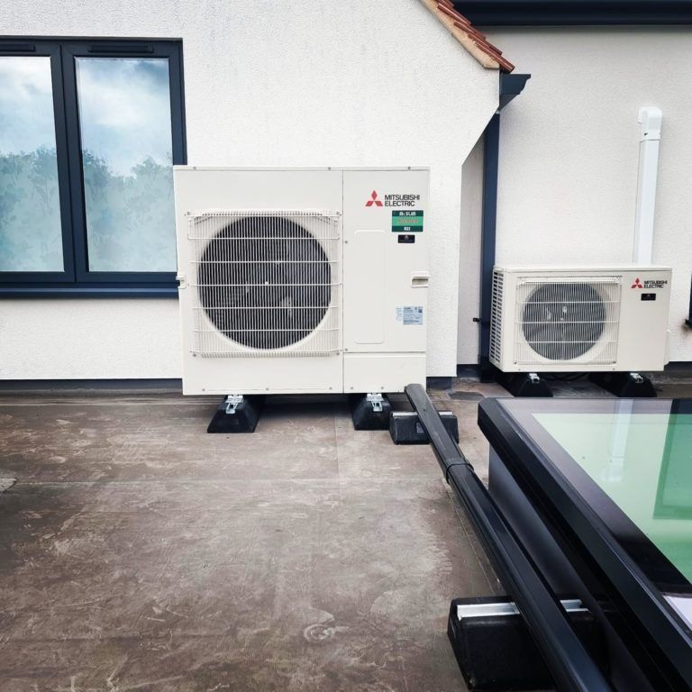 Two mitsubishi air conditioners are on the side of a building