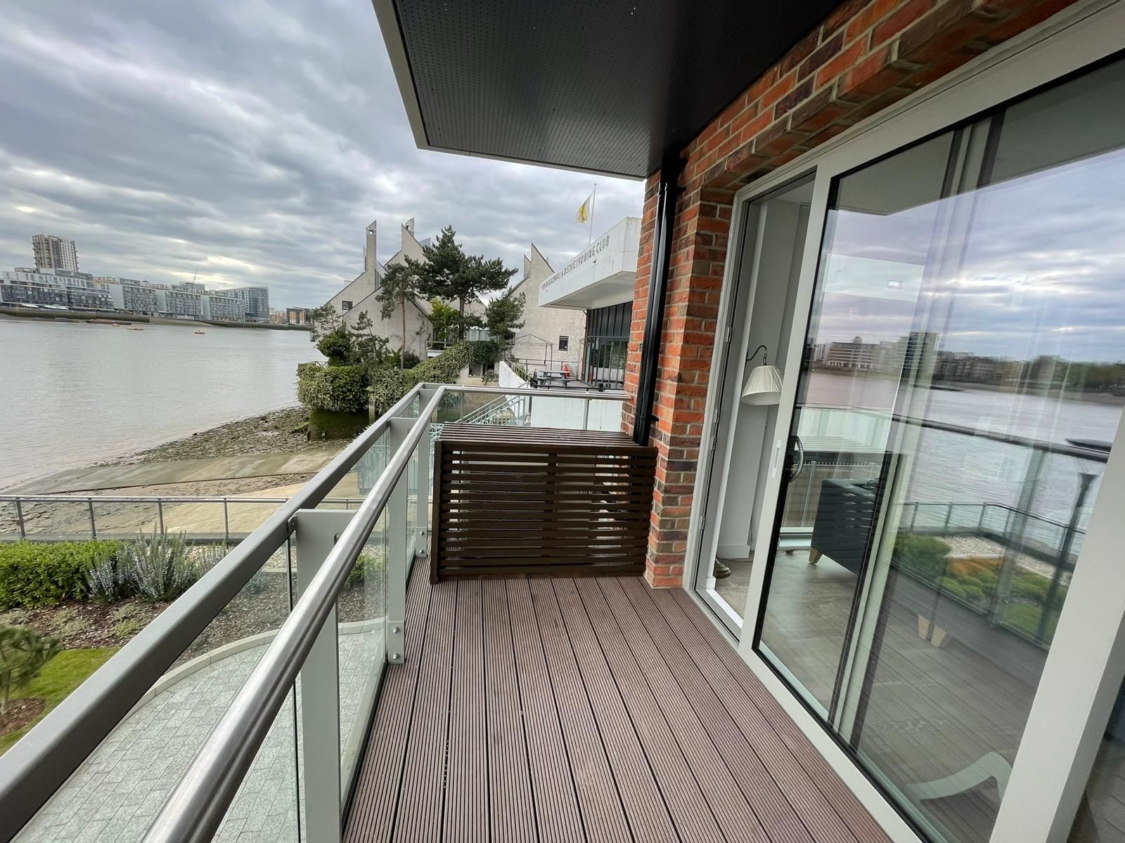 A balcony with sliding glass doors overlooking a body of water.
