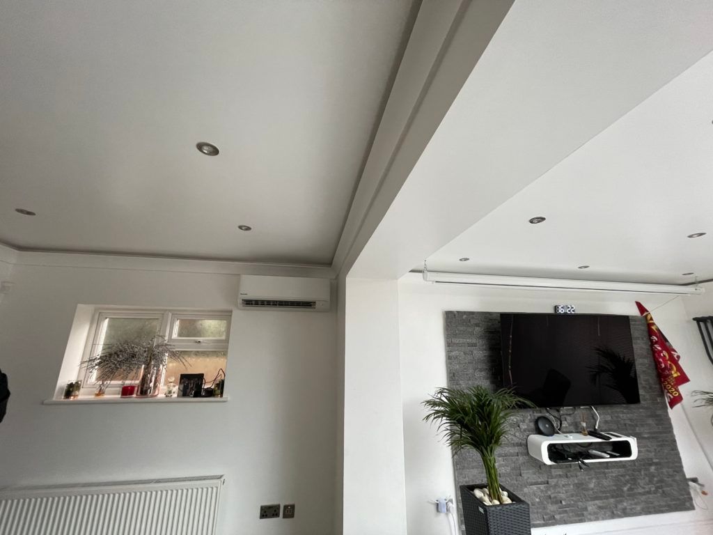 A living room with a flat screen tv on the wall.