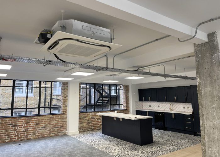 An empty kitchen with a large island and a ceiling fan.