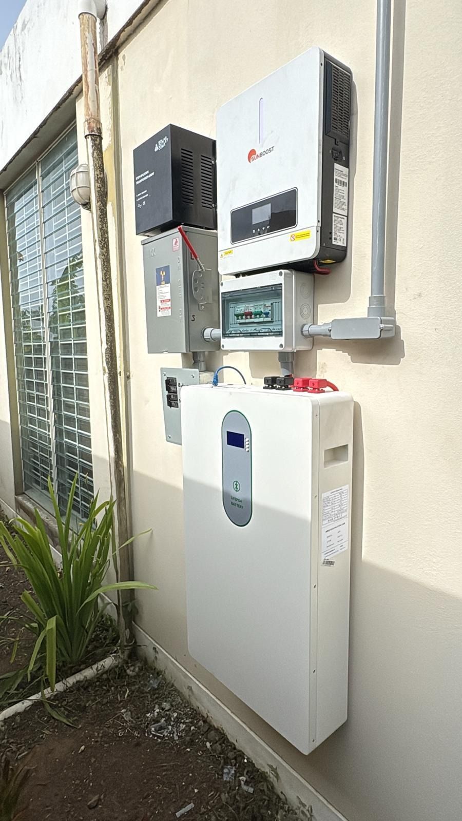 Equipo eléctrico montado en la pared y una gran caja de control blanca en la pared exterior del edificio.