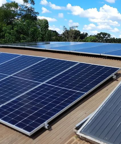 Paneles solares en la azotea con conjuntos fotovoltaicos azules bajo un cielo parcialmente nublado.