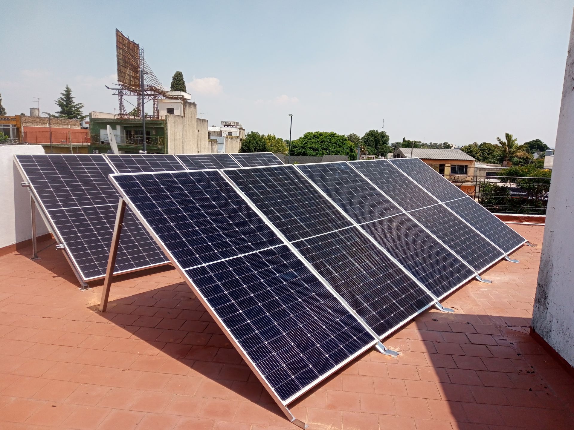 Paneles solares instalados en una terraza en la azotea bajo un cielo despejado.