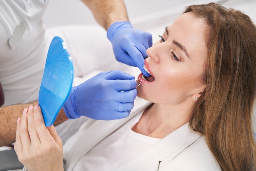 A woman is getting her teeth examined by a dentist.