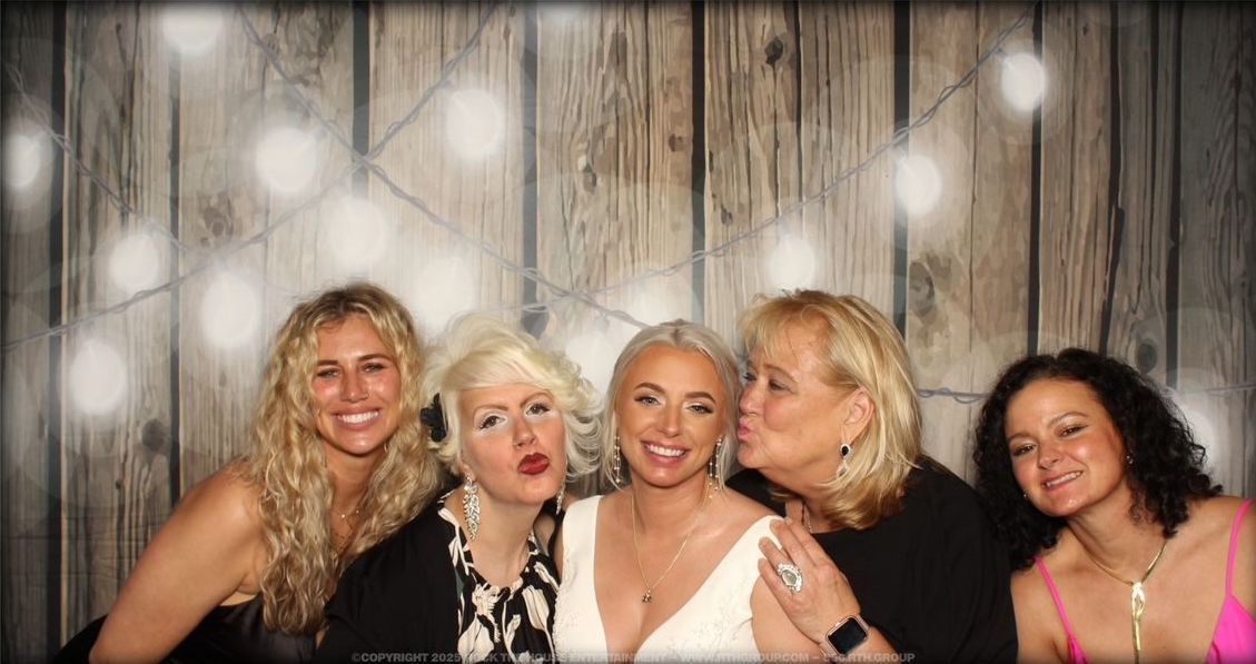 A group of women are posing for a picture in a photo booth.