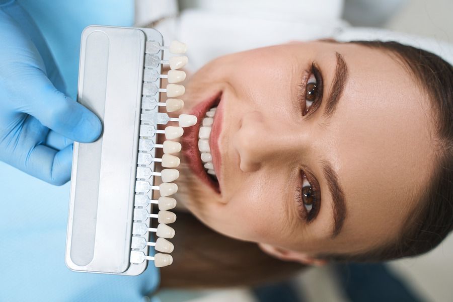 A woman is getting her teeth whitened by a dentist.