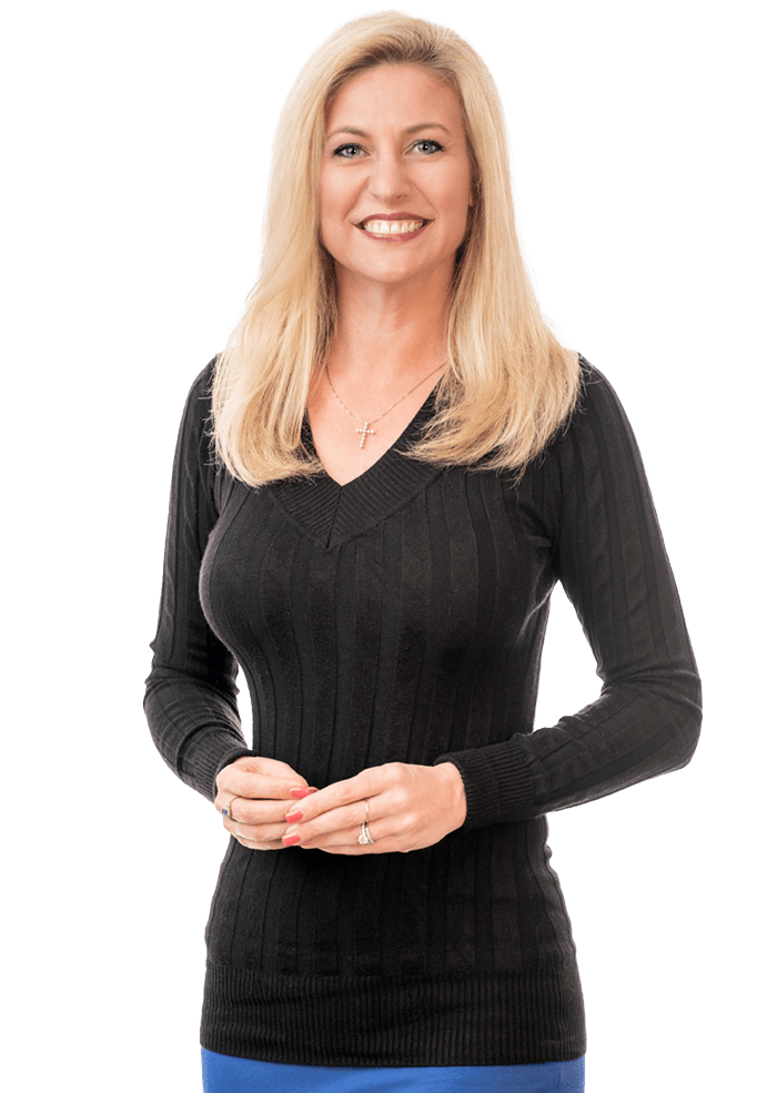 Woman with blonde hair wearing a black sweater and blue skirt, smiling at the camera.
