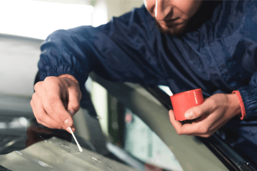 an auto glass expert trying to repair a broken glass