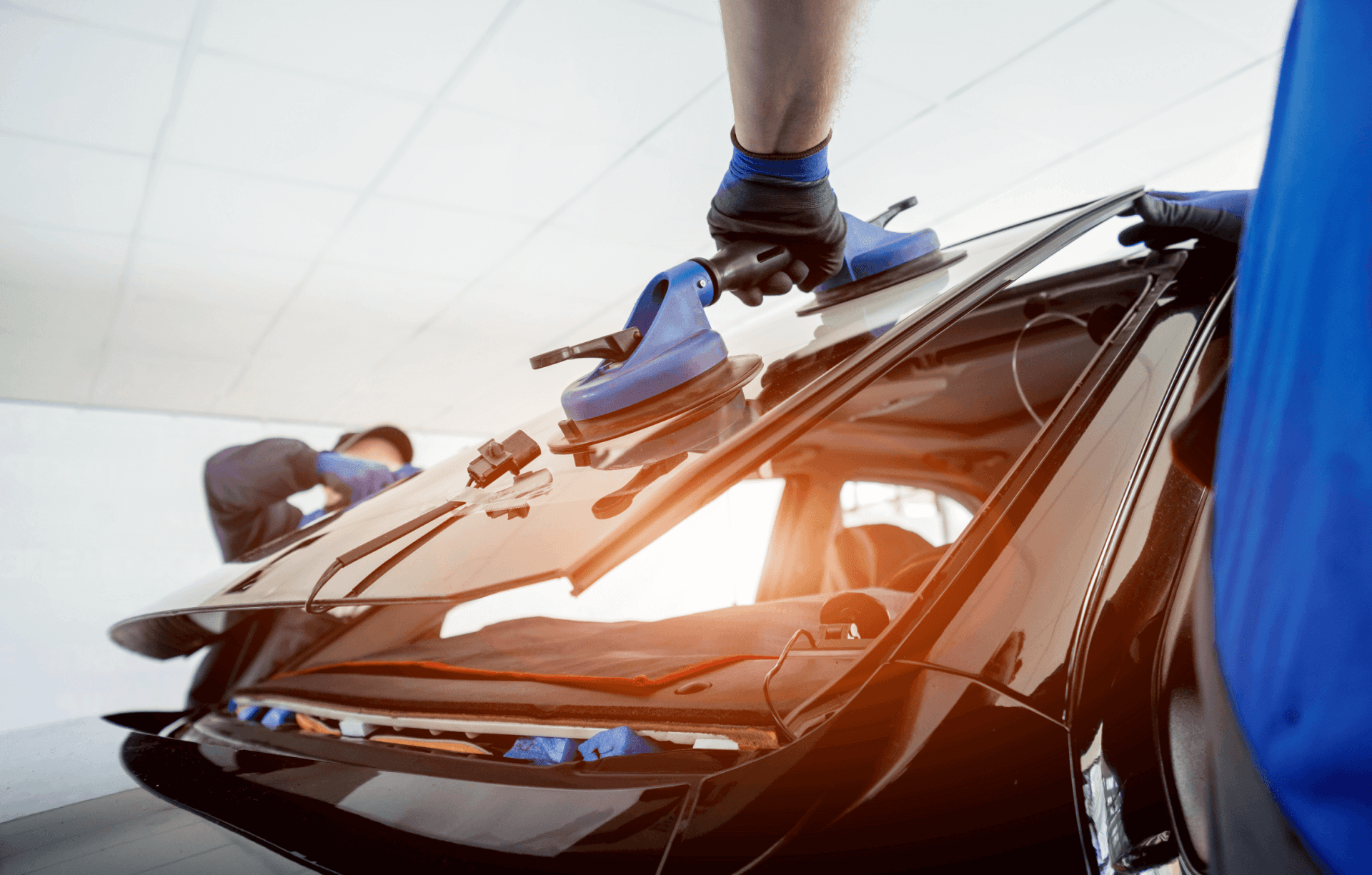 technicians installing a windscreen onto a car