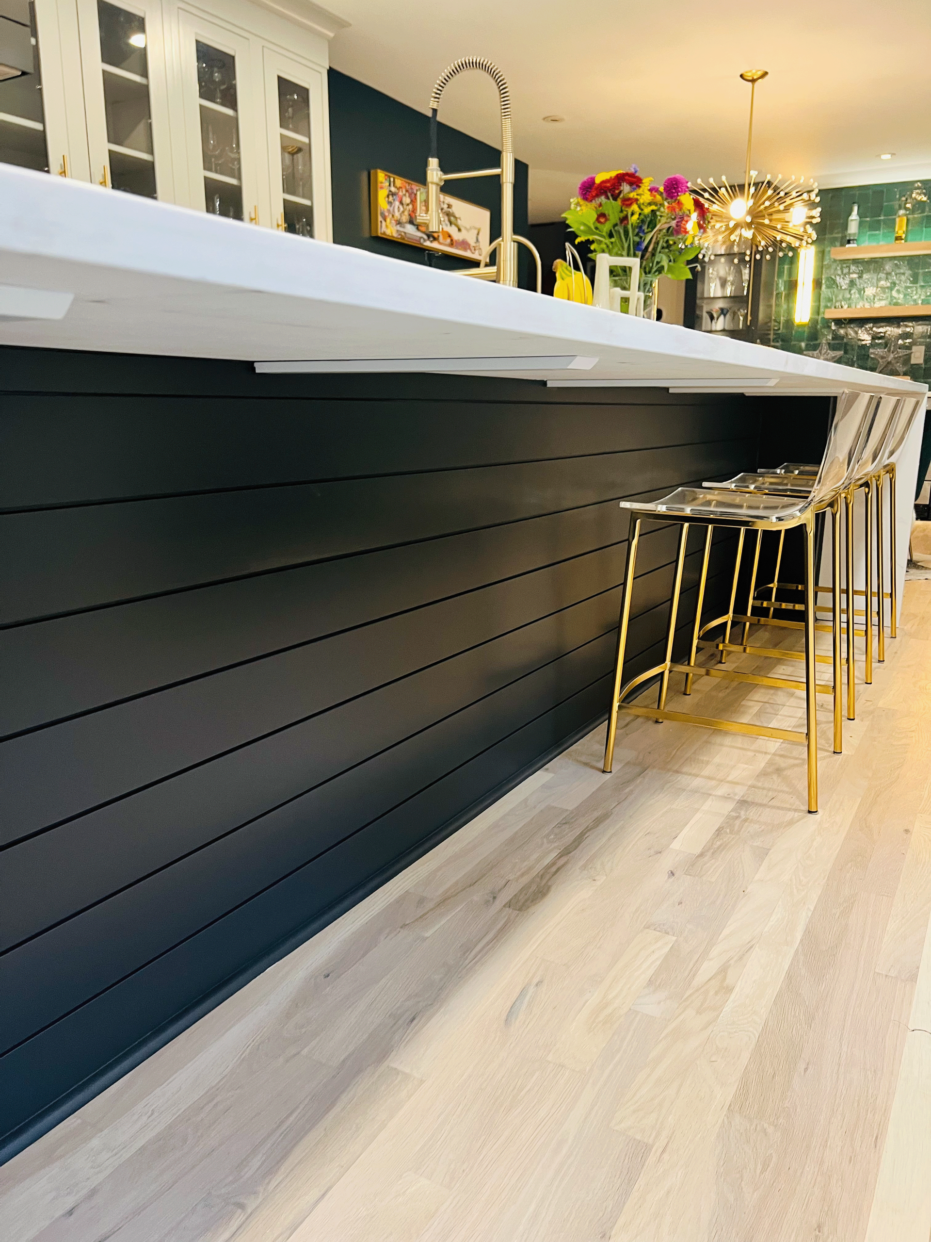 A kitchen with a long counter top and stools