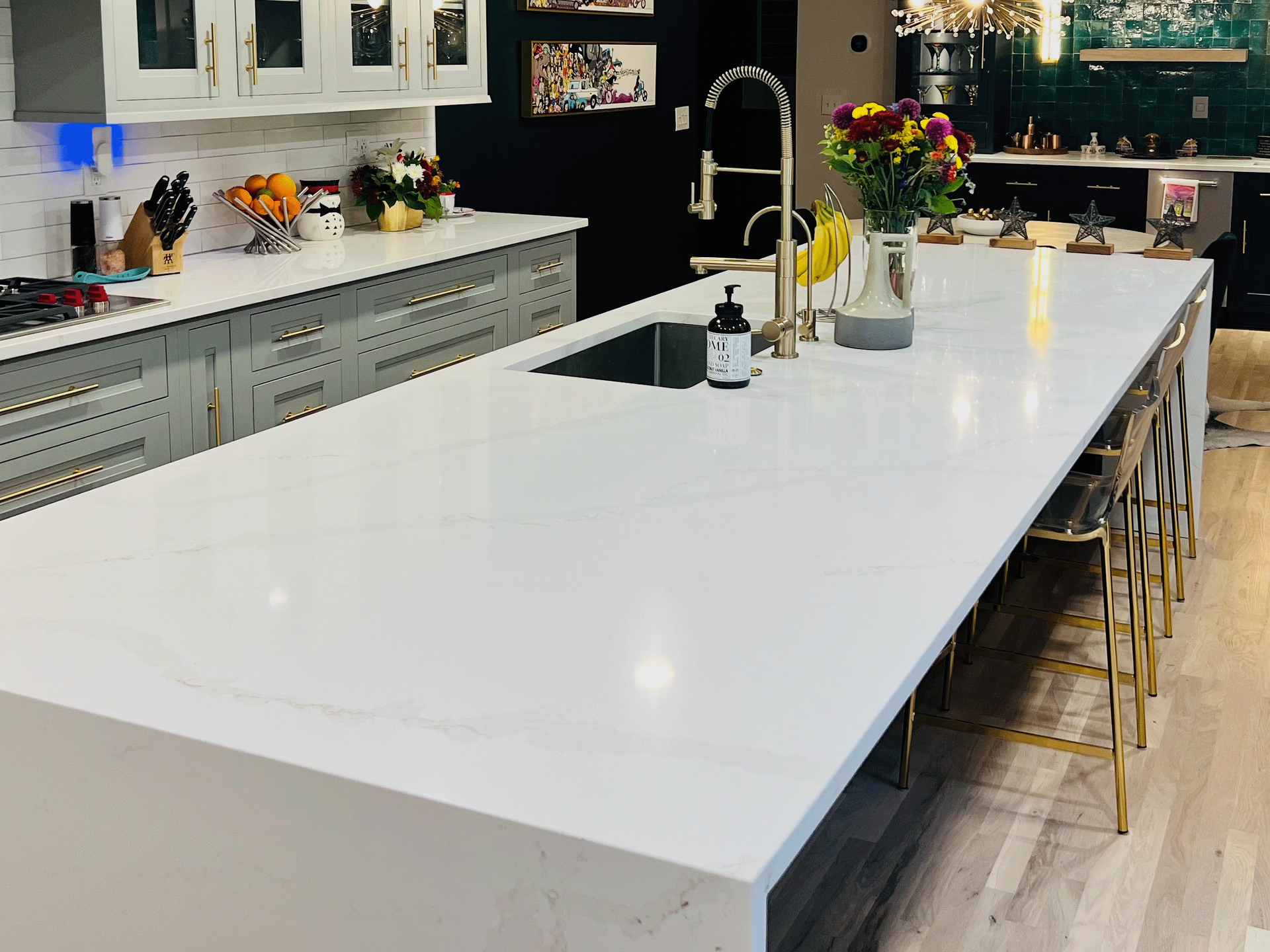 A kitchen with a large white counter top and a sink.