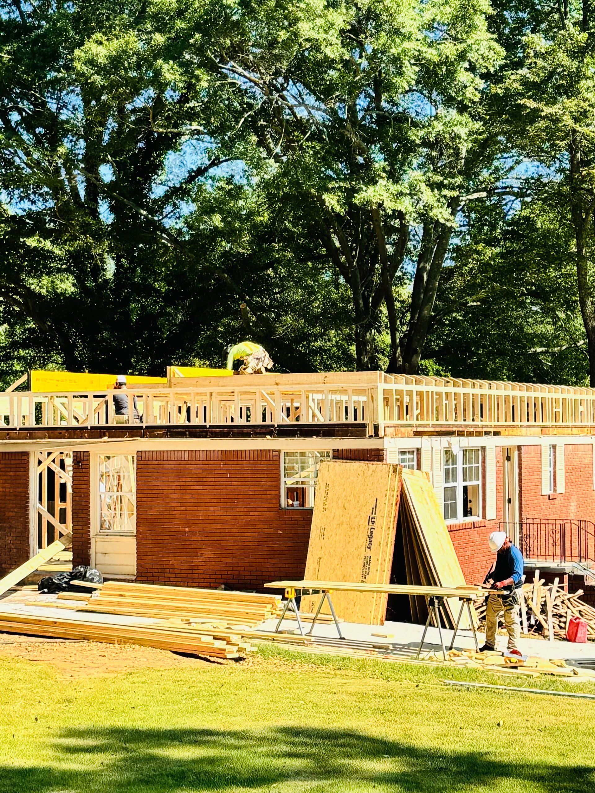 A man is standing in front of a house under construction.