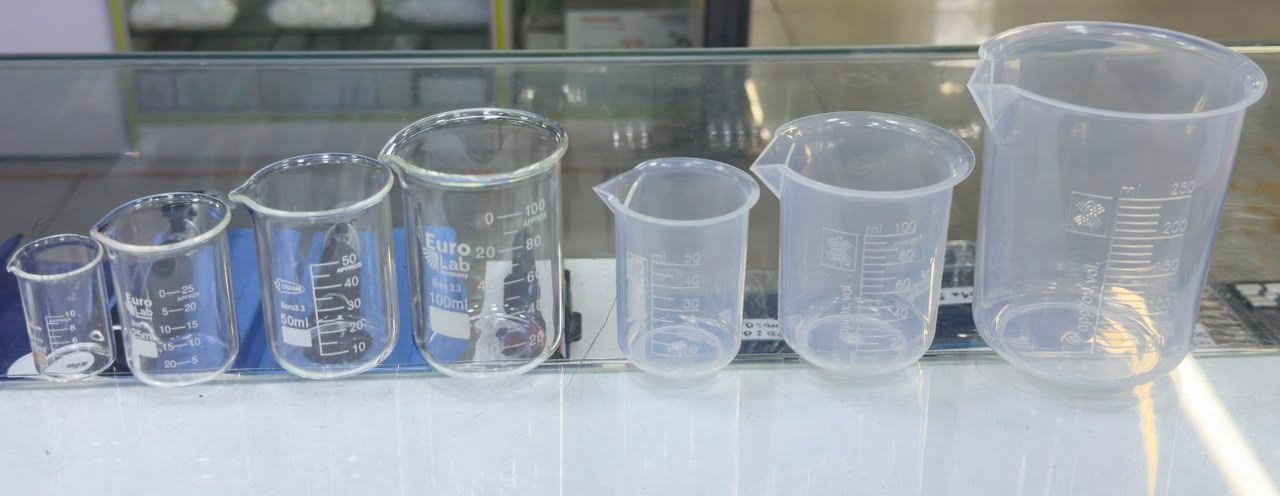 Una hilera de vasos medidores de plástico transparente de diferentes tamaños sobre una encimera