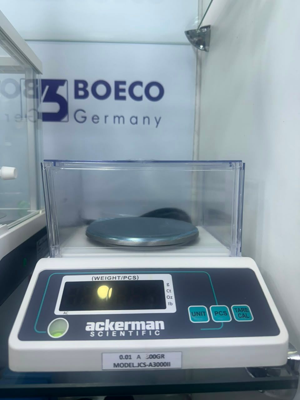 Balanza digital en una carcasa de laboratorio con la marca BOECO Alemania y plato para muestras en la parte superior.
