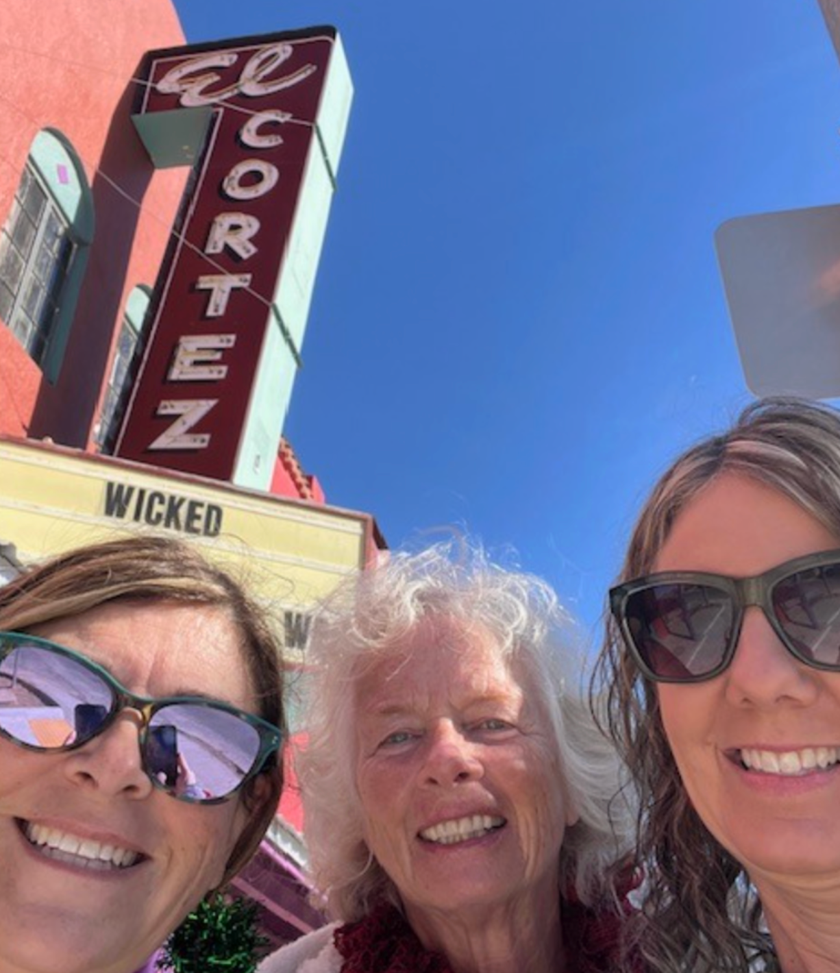 Three people smiling in front of the