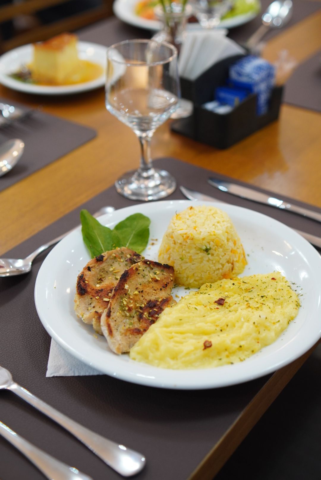 Um prato de comida com carne e purê de batatas sobre uma mesa.
