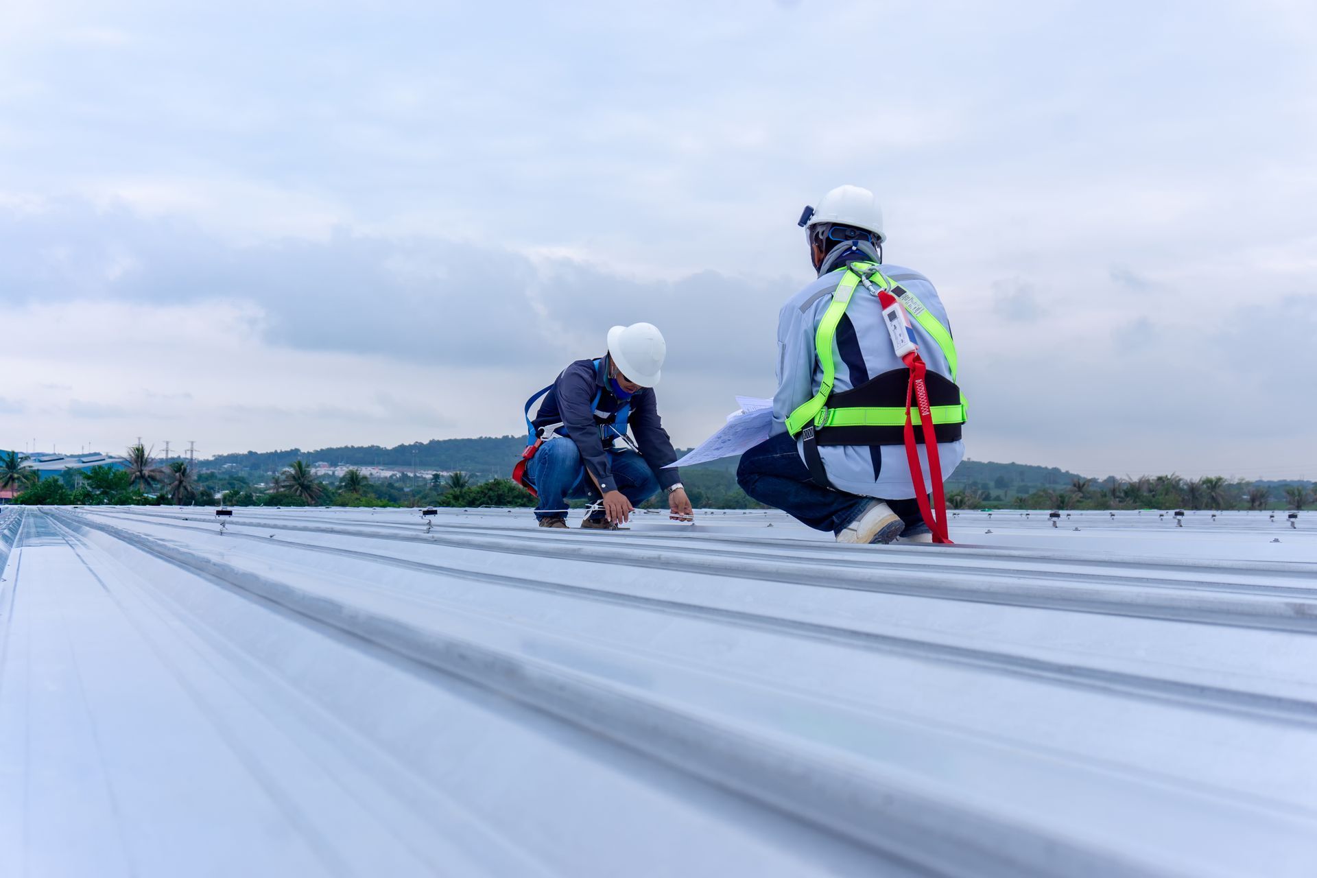 Contractors performing roofing inspection on a commercial metal roof