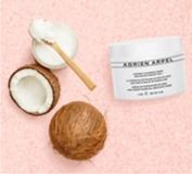 Coconut skincare jar with half and whole coconuts on a pink background