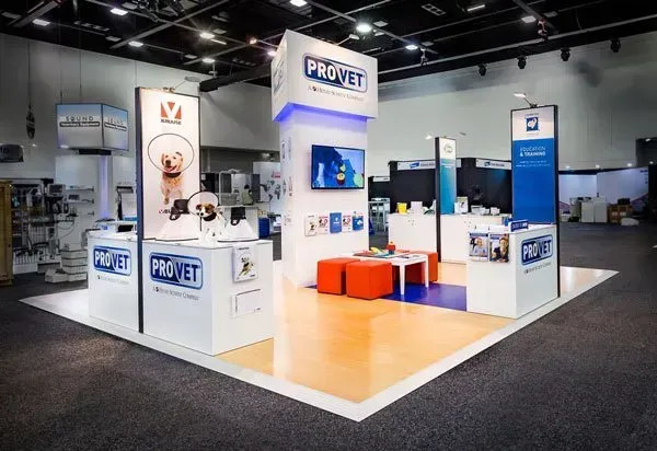 PROVET trade show booth with blue, white, and orange accents, featuring display screens and seating.