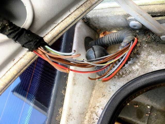 A person in a plaid shirt flips a breaker switch in a gray electrical service panel.