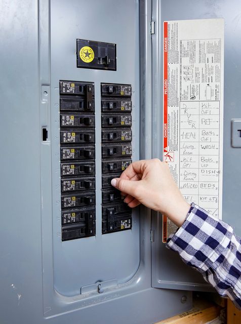 Fuse box with two cylindrical fuses and wiring inside a metal enclosure.