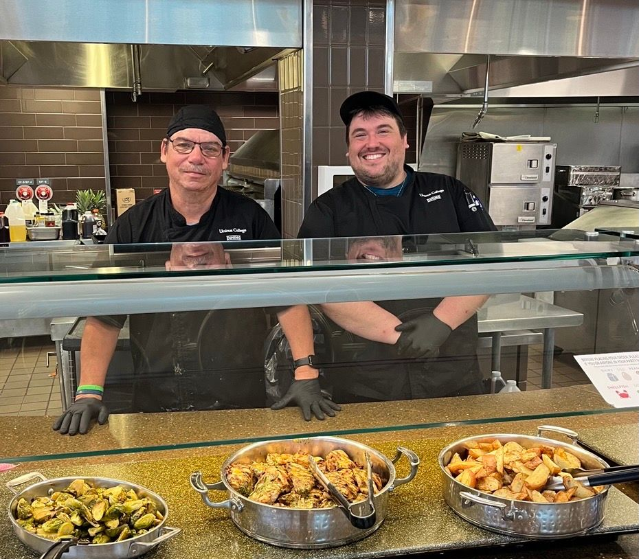 A man in a chef 's hat is posing for a picture with two other chefs