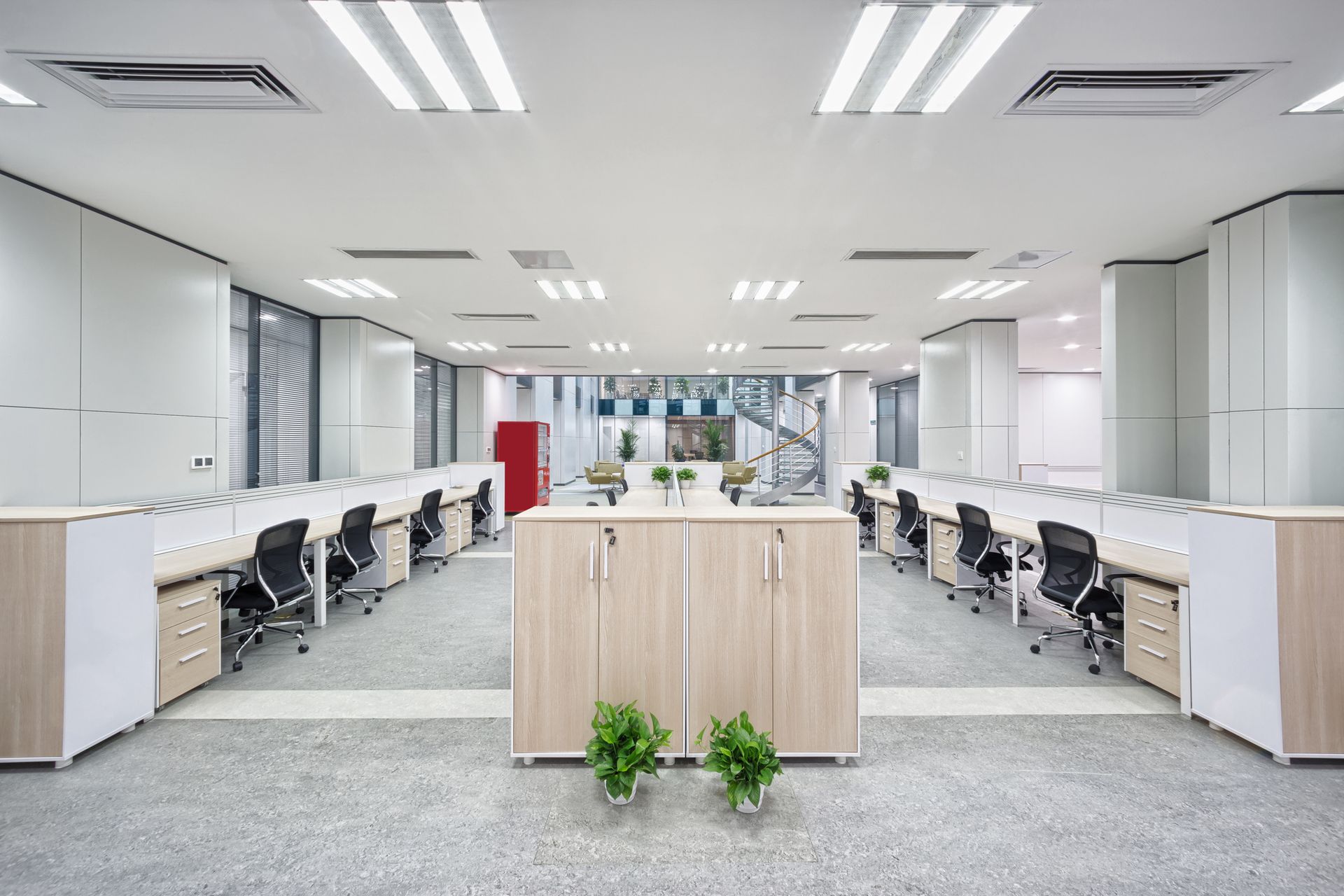 A large empty office with lots of desks and chairs.