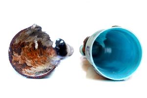 Two small insulated cups, one brown and worn, one blue inside, shown side by side on white.