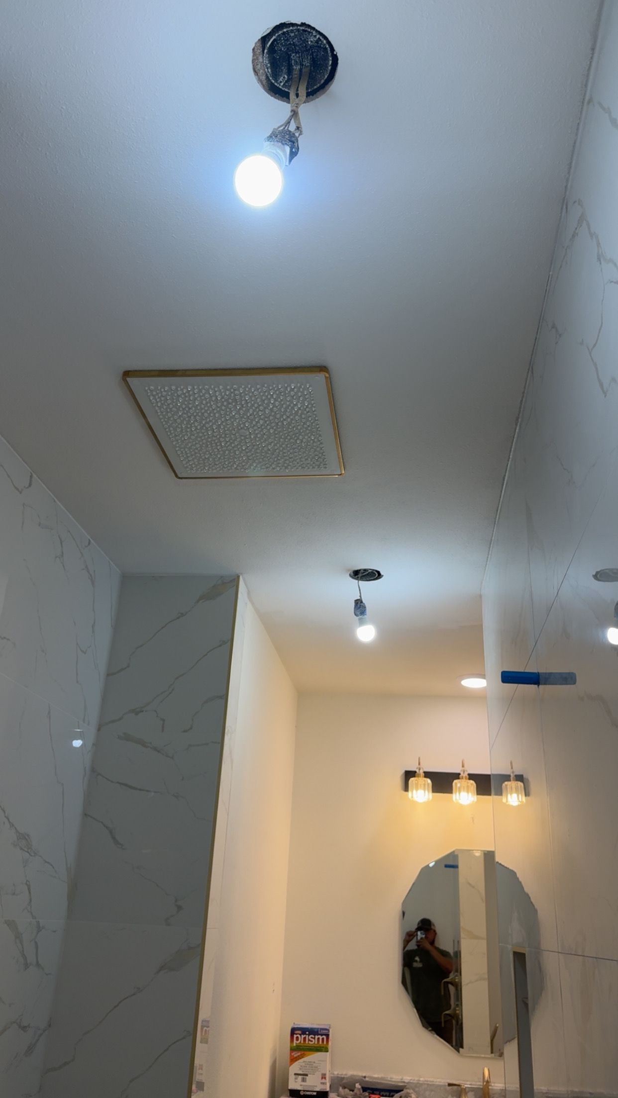 Narrow hallway with ceiling lights, a decorative mirror, and a wall-mounted shelf in a modern interior.
