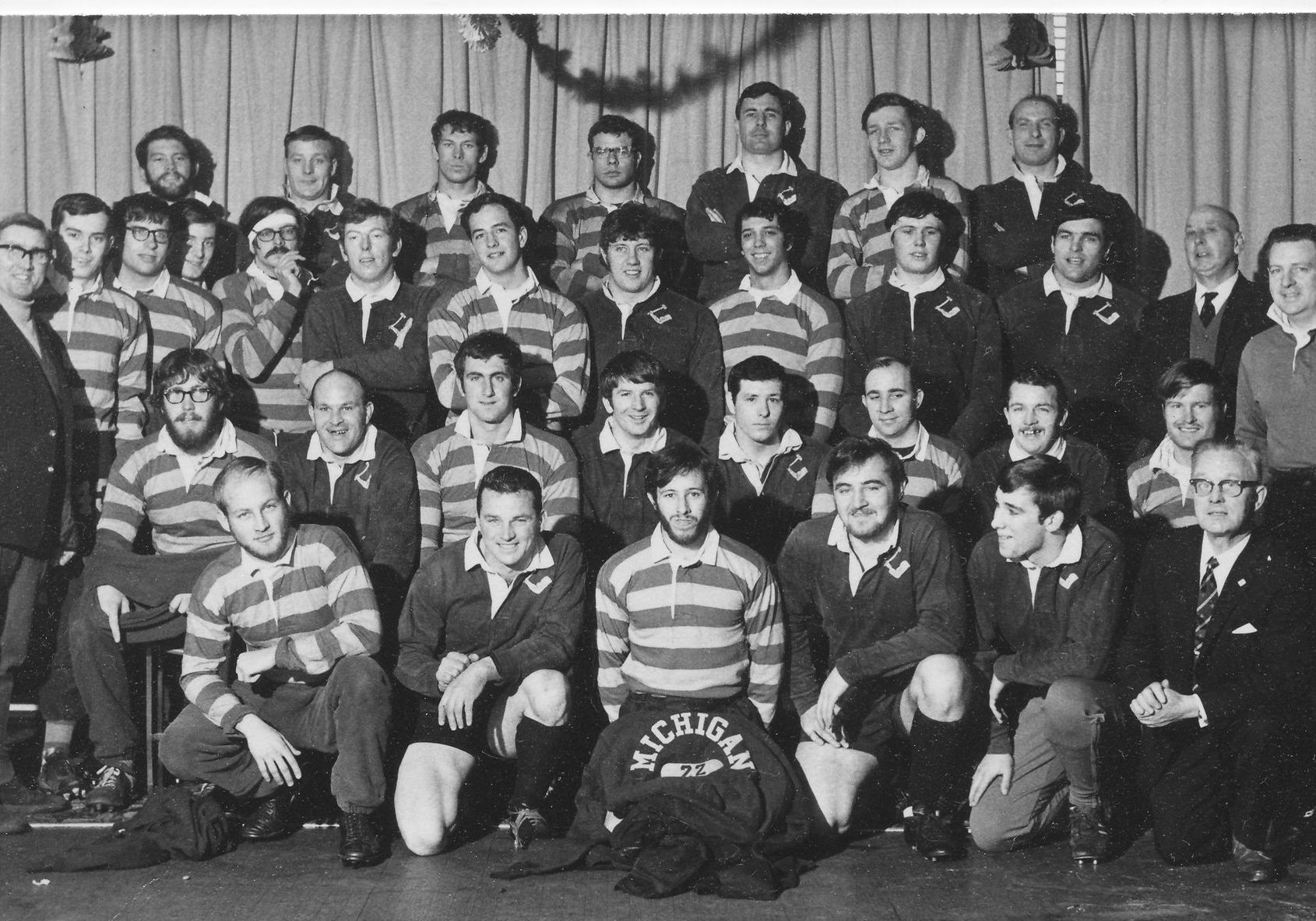 A black and white photo of a group of men posing for a picture