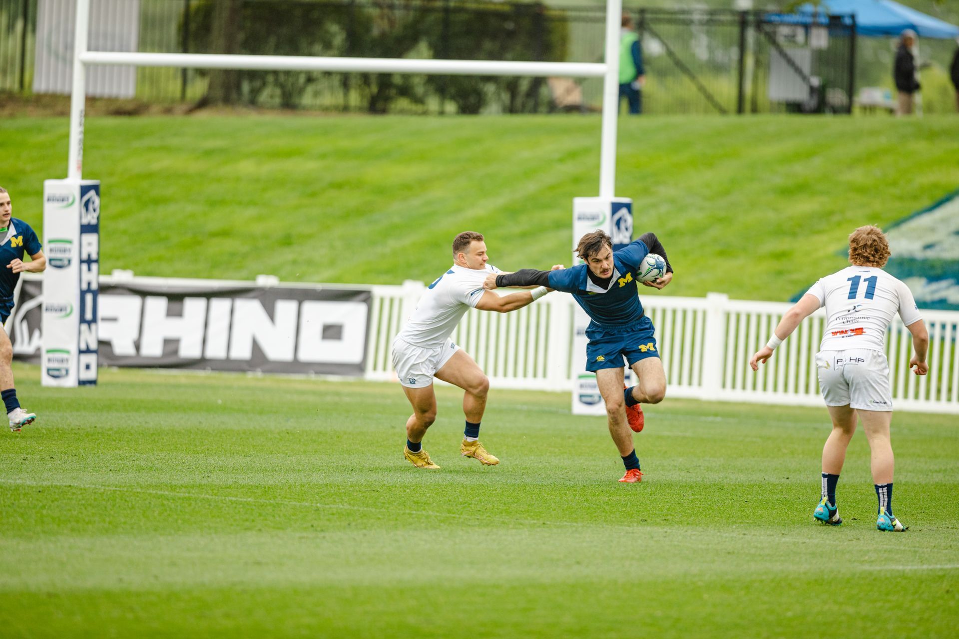 A group of men are playing rugby on a field.