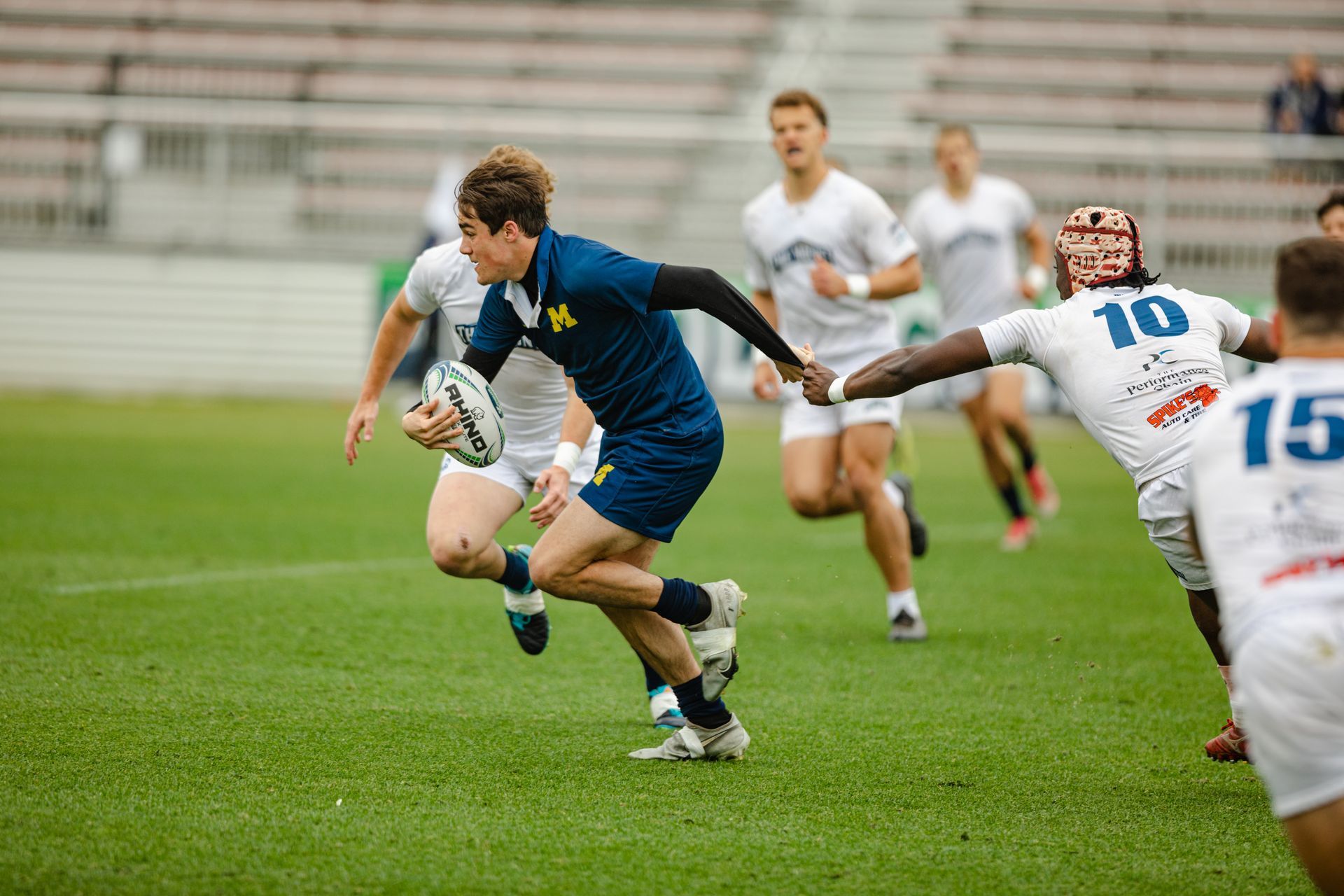 A group of men are playing rugby on a field.