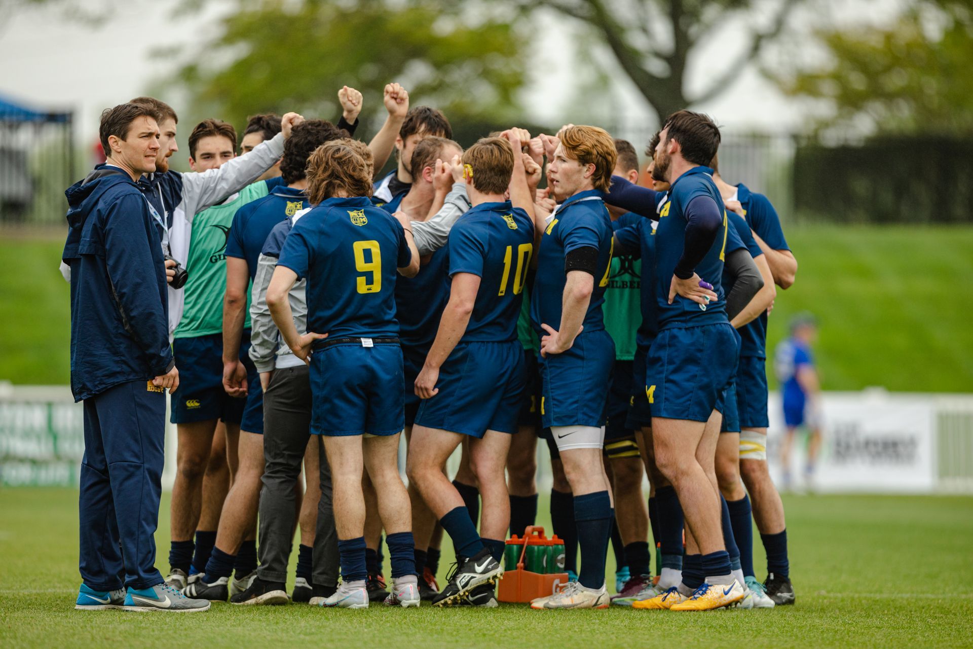 A group of rugby players are huddled together on a field.