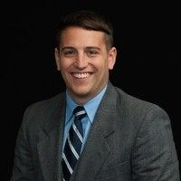 A man in a suit and tie is smiling for the camera.