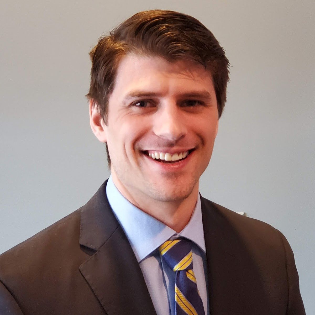 A man in a suit and tie smiles for the camera