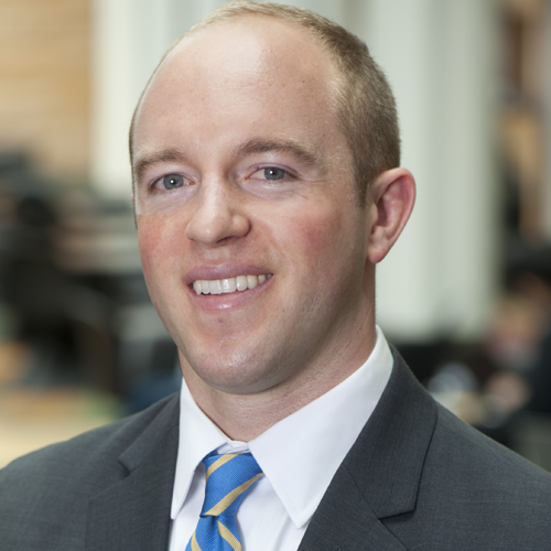 A man in a suit and tie is smiling for the camera