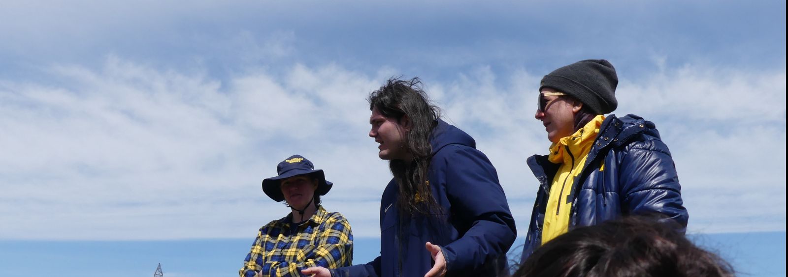 A group of people are standing on top of a hill.
